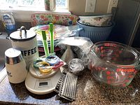 Overall lot showing dinner plates, tray, bowls, scale, canister, utensils