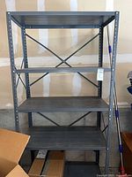 Full view of one gray metal shelving unit