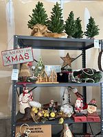 Overall view of shelving with trees, sign, figurines and other Christmas items