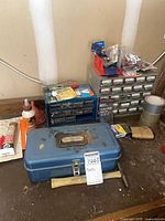 Workbench view with blue toolbox, hardware cabinets, adhesives and hardware
