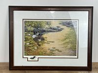 Full view of framed, matted print showing loons scene, wood frame