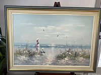 Full view of framed painting on easel