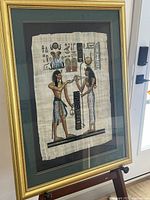 Full view of framed Egyptian papyrus artwork on easel