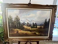 Full view of framed landscape painting with picture light