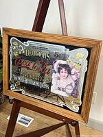 Full view of framed Coca-Cola advertising mirror on easel