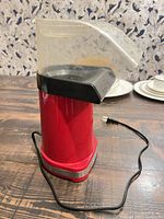 Full view of red Cuisinart air popper showing cord and chute