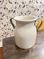 Front view of cream ceramic jug with black handles