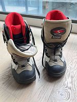 Front view of both snowboard boots showing logo, laces, toe condition
