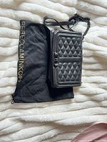 Handbag resting on dust bag showing size and overall design