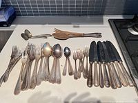 Overall view of assorted forks, spoons, knives, ladle, salad servers