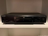 Front view of Sony DVD player showing model information and controls