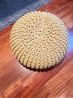 Top view of round woven mustard yellow pouf