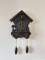 Full view of cuckoo clock hanging with weights