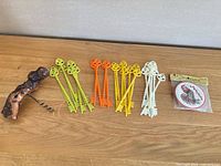All items: 26 plastic skeleton key stirrers arranged by colour, grapevine wood corkscrew, sealed Crest coasters pack