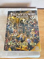 Front of sealed Pathfinder Pawns NPC Codex Box on battle mat