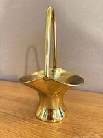 Front view of brass basket holder showing overall form and handle