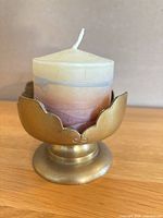 Brass pedestal candle holder front view with candle