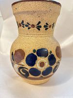 Front view showing floral design and speckled clay surface