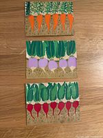 Three vegetable silk-screen cards on wood surface