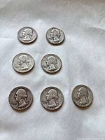 Seven Washington quarters laid out obverse side showing dates