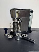 Front view of espresso machine with all accessories laid out