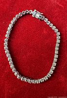 Full view of sterling silver tennis bracelet on red background