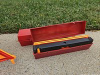 Red plastic case opened showing folded triangle