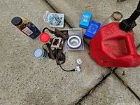 Lot overview showing gas can, hardware containers, straps, bowl, regulator