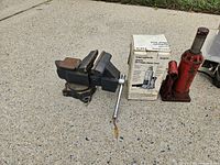 bench vise, grey jack in box, red jack grouped on pavement