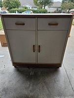 Front view showing drawers, doors, wood trim and handles