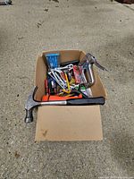 Full view of cardboard box with assorted hand tools