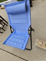 Blue folding lounge chair showing full frame and headrest pillow
