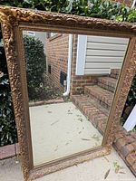 Full view of mirror front showing ornate gold frame and clear glass