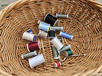 Assorted thread spools in basket
