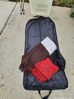 Garment bag laid out with four scarves displayed; storage drawer visible in background