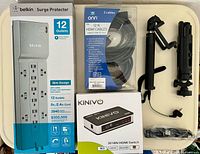 Boxed Belkin surge protector, onn. HDMI cable pack, Kinivo HDMI switch box, tripod selfie stick folded