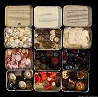 Open Sucrets tins showing assorted buttons sorted by colour