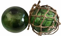 Two large green glass floats, one netted