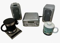 Front view of Magnavox stereo, speakers, Cosori mug warmer set and ceramic mug