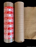 Two honeycomb paper rolls side by side, one wrapped with red FRAGILE tape, other unwrapped showing texture