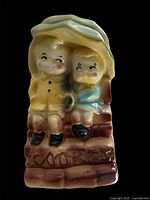 Front view of ceramic cookie jar showing children under umbrella
