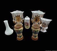 Front view of all seven vases displaying designs and colours