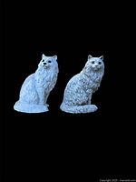 Front view of both white Persian cat statues