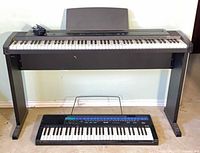 Roland ep.9 digital piano on stand with Casio Tone Bank 210 keyboard beneath