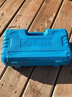 closed blue Saker carry case on wooden deck