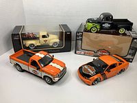Four vehicles grouped: orange F-250, orange Mustang, sealed cream 1953 Chevy, black/green flame 1948 Ford on box