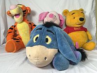 Group shot of Tigger, Eeyore, Pooh, Piglet plush toys
