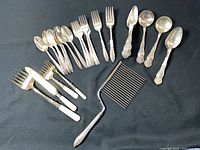 Group shot of all flatware pieces and cake breaker