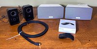 Group shot of Logitech speakers, Sonos speakers, HDMI cable, boxed Arc Touch mouse and loose mouse