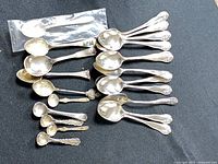 Full lot showing 12 matching teaspoons and nine assorted spoons
